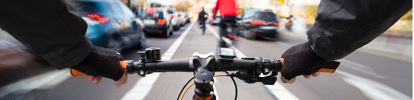 Radfahrer im Stadtverkehr Radfahrer fährt auf dem Radweg durch den Stadtverkehr - Bild aus der Perspektive des Radfahrers.