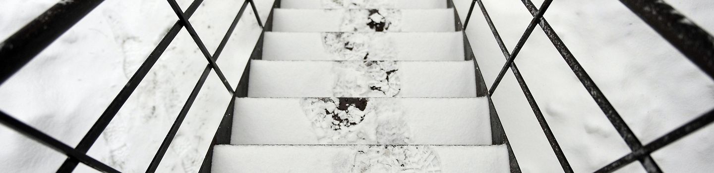 Winter Treppe mit verschneiten Stufen, auf denen Fußspuren zu sehen sind